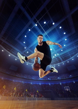 Dynamic image of young man, professional basketball player in motion, jumping with ball during match...