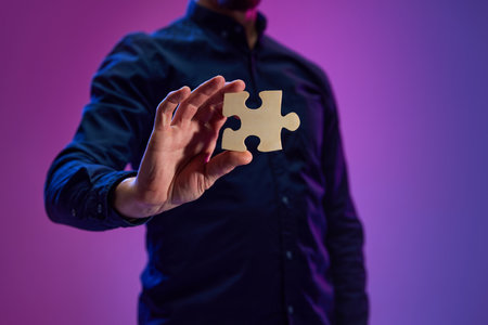 Businessman holding puzzle symbolizing teamwork, partnership, business cooperation and successful strategyの写真素材