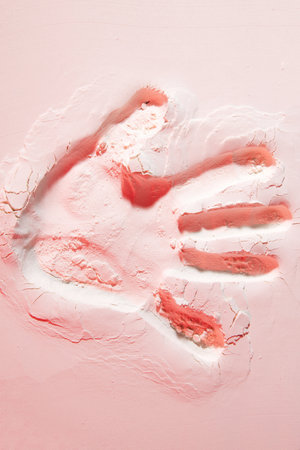 Creative, stunning background of wallpaper featuring a vivid handprint on a beautiful pink sand...