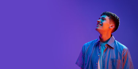 Portrait of positive young guy in casual clothes smiling, posing with good mood against gradient...