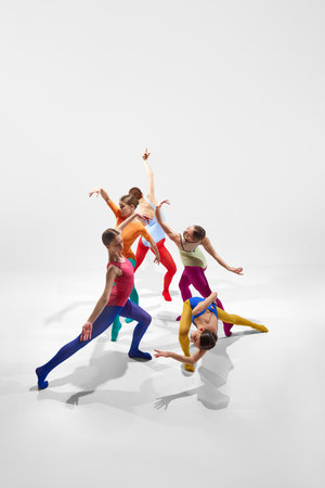 Top view. Creative, expressive young girls, ballerinas in colorful bright tights dancing against grey studio backgroundの写真素材