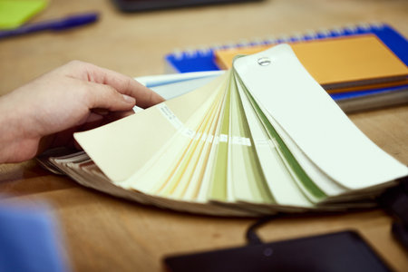 Close-up image of persons hands, graphic designer working with colour palette, swatch samples.の写真素材