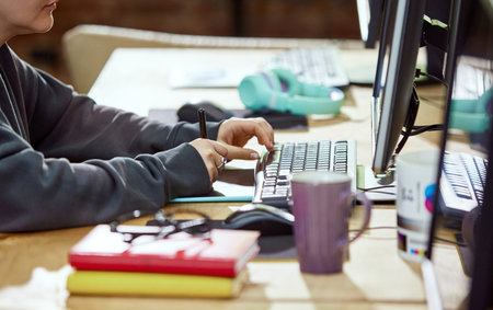 Close-up image of female hands, graphic designer, retoucher working with graphic tablet and stylus, editing photosの写真素材