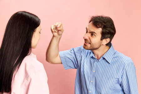 Man emotionally talking to woman, expressing anger, disagreement and irritation against pink studio...