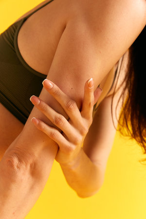 Cropped image of female body, hands against yellow studio background. Manicure. Care. cosmetology,...