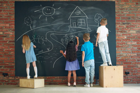 Little boys and girls, children drawing on blackboard, spending time together, studying, learning, playingの写真素材