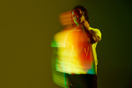 Stylish you guy with dress posing in casual clothes in gradient green background in neon light....