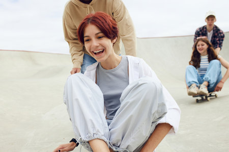 Close-up of smiling, laughing, positive teen girl spending good time with friends on skate park, skateboardingの写真素材