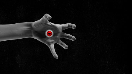 Black and white image of female hand with terrifying red eyes on palm. Magic vision. Contemporary...