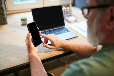Senior businessman using mobile phone for communication and work. Modern technologies in professional sphereの写真素材