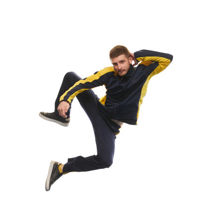 Stylish young man in sportswear jumping and looking at camera isolated on white backgroundの写真素材
