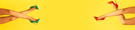 Female slender legs in red and green heels over bright yellow background. Sales, shopping seasonの写真素材