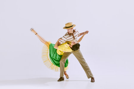 In a good mood. Beautiful young woman and handsome man, couple dancing together isolated on white studio backgroundの写真素材