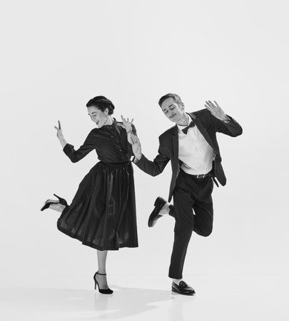 Rhythmic. Black and white. Stylish, elegant young couple, man and woman in stylus clothes dancingの写真素材