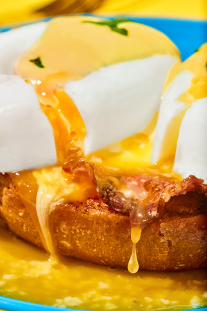 Close-up of poached eggs with liquid yolk and bacon on toasted bun. Breakfast, food. Pop art
