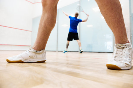 Young sportive men, friends playing squash together on squash court. Heathy leisure time togetherの写真素材