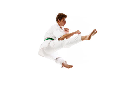 Flying kicks. Professional martial arts athlete, karateka in white kimono training, practicing...