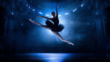 Beautiful, elegant, artistic young woman, ballerina in motion, jumping, dancing on theater stage with spotlightsの写真素材
