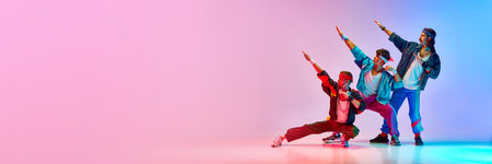 Funny image of three men in stylish, vintage sportswear training aerobics and gymnastics against gradient blue pink studio background.の写真素材