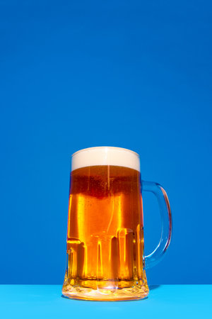 Mug with lager, foamy, fresh beer isolated on blue background. Traditional taste, degustation. Posterの写真素材