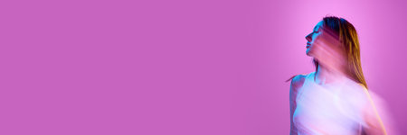 Portrait of young elegant woman in casual clothes posing against light purple background in neon...