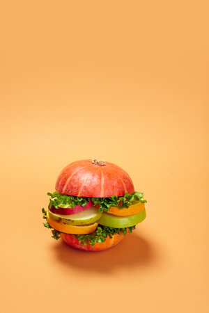 Healthy burger made with fresh vegetables and fruits against orange background. Organic products and healthy foodの写真素材