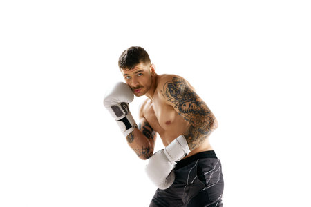 Protection. Young muscular shirtless man, boxing athlete training isolated over white backgroundの写真素材
