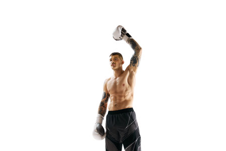 Winner, champion. Young shirtless man with muscular strong body, boxing athlete raising hand isolated over white backgroundの写真素材