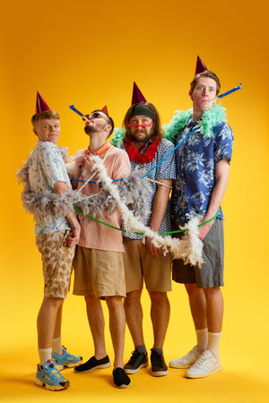 Birthday party. Friends, stylish emotion men tied with decorations, celebrating against yellow...