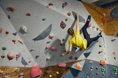 L:ittle girl, child attending bouldering course, training, climbing wall indoors. Sport educationの写真素材