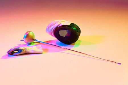 fence athlete equipment. Mask and fencing sword on light background in neon light