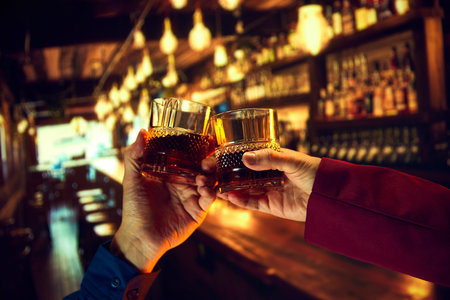 Corporate event services offering a whiskey bar for events. Male hands, businessmen clinking whiskey glasses, meeting at pubの写真素材
