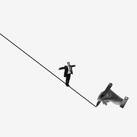 Businessman balancing on line being drawn by human hand. Overcoming challenges and obstacles, adaptability and flexibility of employee. Creative design.の写真素材