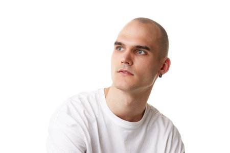 Portrait of handsome bald man with shaved clear spotless face and ear piercing posing isolated on white studio backgroundの写真素材