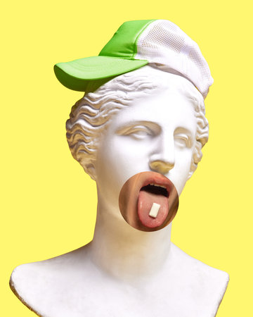 Hipster. Plaster head model with human mouth and bubblegum and green cap element on light yellow...