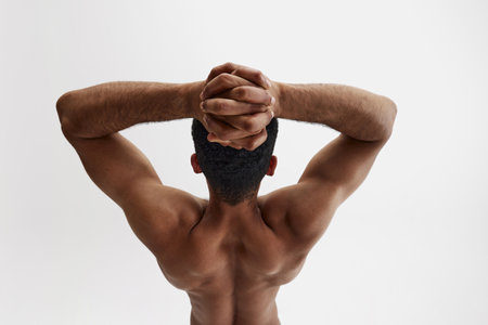 Art of masculinity. Rear view of shirtless young man with muscular relief back and strong hands isolated on white backgroundの写真素材