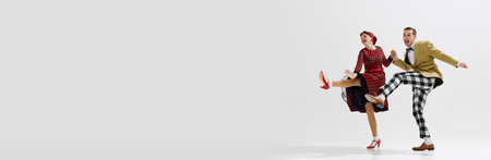 Fun and dynamic photo of young couple, artistic man and woman dancing isolated over white studio backgroundの写真素材