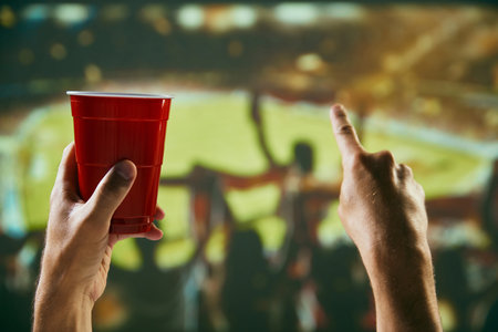 People, sport fans gathering at stadium to watch football competition, supporting team. Celebrating winning game and drinking beerの写真素材