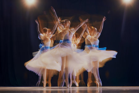 Dancing ballerinas in airy costumes, creating a sense of weightlessness and fluid movements. Photo with long exposure.の写真素材