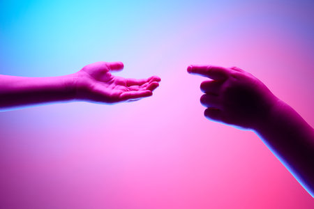 Kids hands gesturing against gradient blue purple background in neon light. Children hands reaching each other. Connectionの写真素材