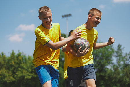 Team Spirit and Fun. Young soccer players express happiness and team spirit during playful moment after winning outdoor game session.の写真素材
