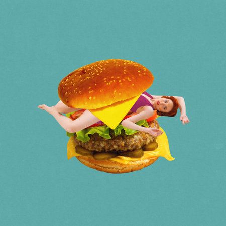 Yung woman lying inside juicy burger against green background. Fast food lover. Contemporary art collage.の写真素材