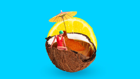 Woman in red swimsuit and green cap sitting inside coconut filled with juice, lemon slice and...