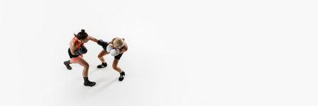 Dyna,ci image of competitive young women, boxing fighters in motion, training isolated on white...