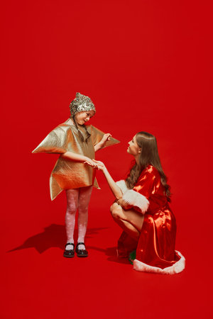Young girl child dressed in star shape costume talking with young woman dressed in festive costume...