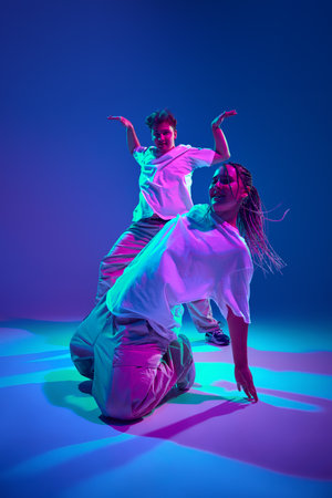 Dynamic performance. Young man and woman, dancers dancing hip-hop, attending contemporary dance show...