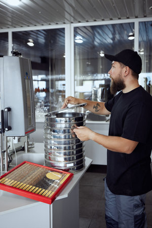 Brewery technologist preparing to analyze grain samples, ensuring the quality and consistency of...