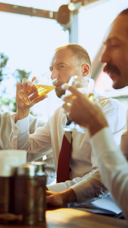 Group of businesspeople, colleagues meeting at local pub, drinking beer, relaxing, talking. Teamwork...