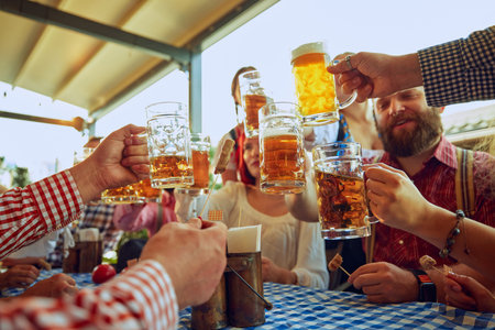 Group of cheerful people, friends, men and women sitting at local pub, drinking beer and having relaxing weekendの写真素材