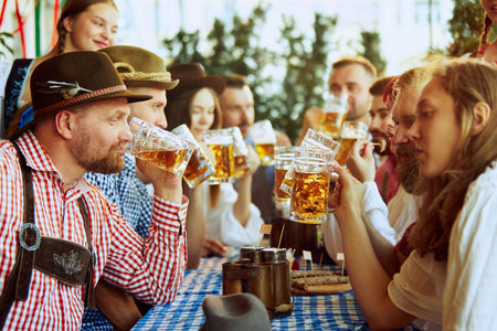 Group of people, men and women meeting at pub, drinking beer with enjoyment. Traditional celebration of beer festivalの写真素材